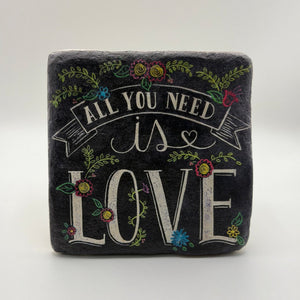 Quotable phrase 'All You Need is Love' printed on square travertine stone coaster