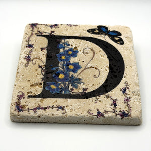 Alphabet letter D design printed on a natural stone coaster