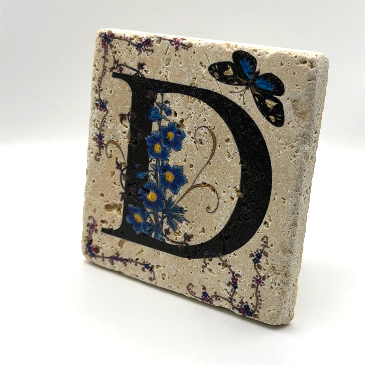 Alphabet letter D design printed on a natural stone coaster