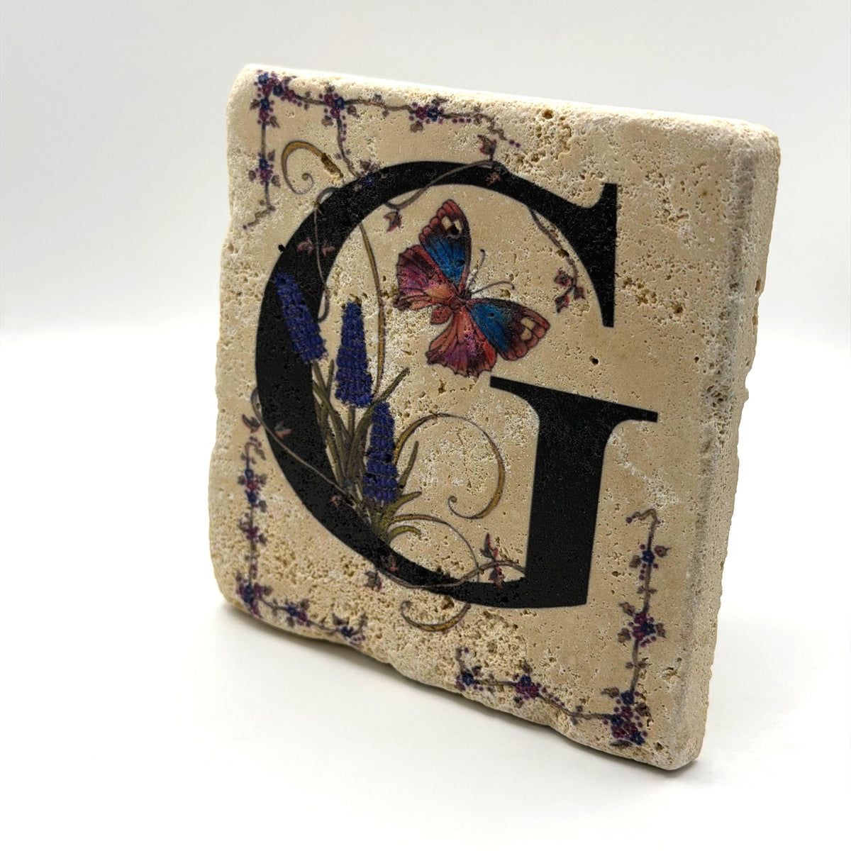 Alphabet letter G design printed on a natural stone coaster