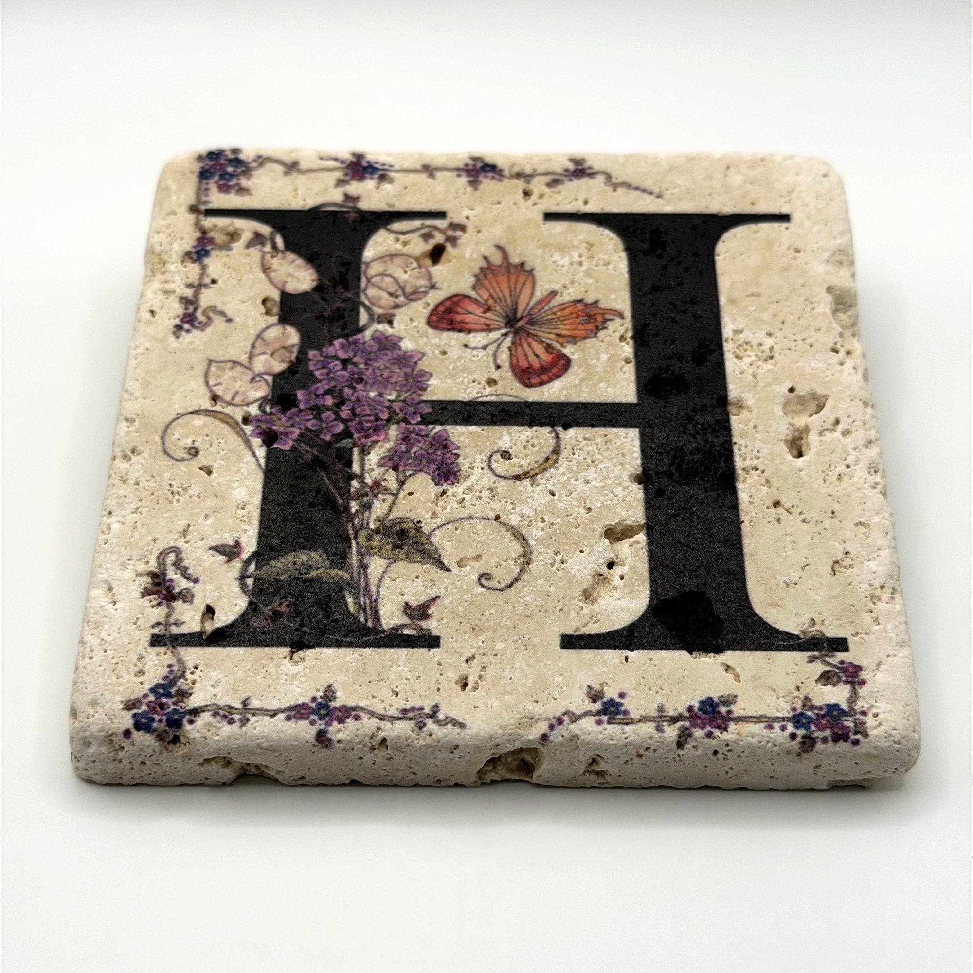 Alphabet letter H design printed on a natural stone coaster