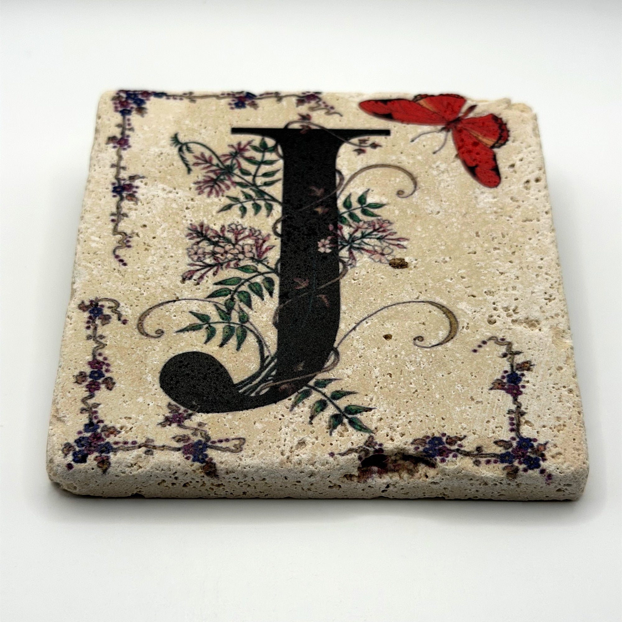Alphabet letter J design printed on a natural stone coaster