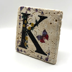 Alphabet letter K design printed on a natural stone coaster