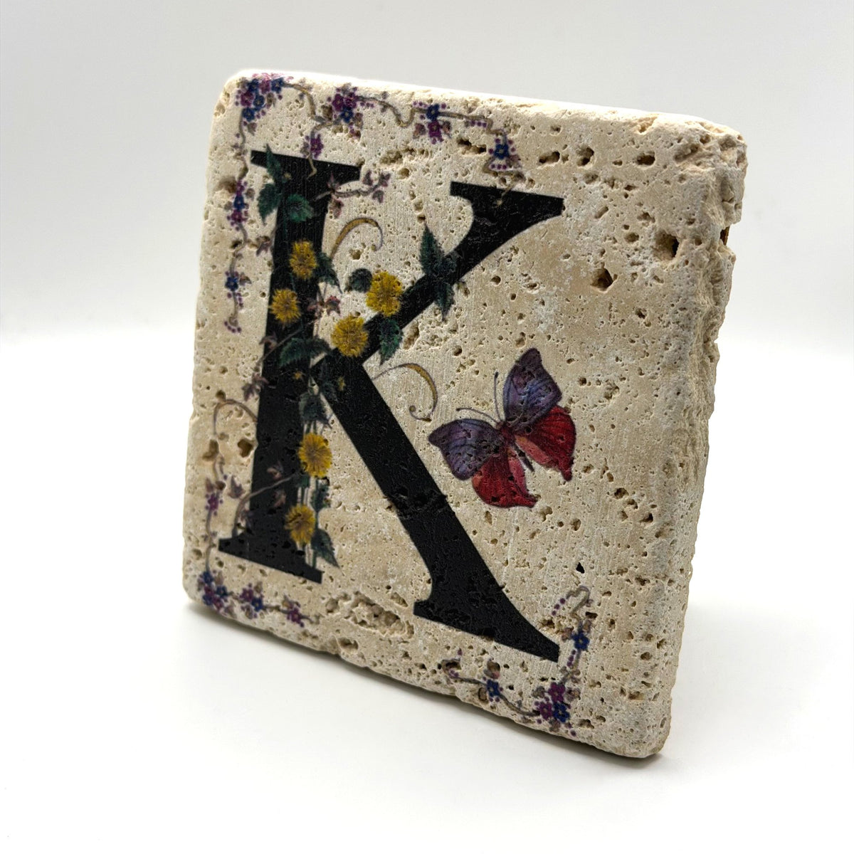 Alphabet letter K design printed on a natural stone coaster
