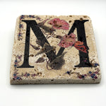 Alphabet letter M design printed on a natural stone coaster