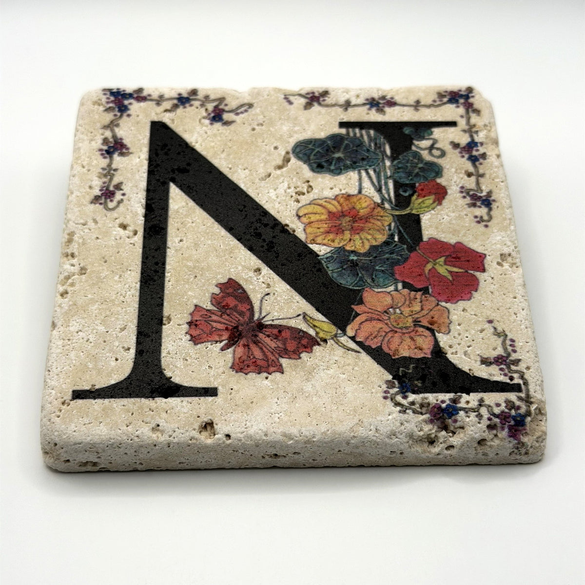 Alphabet letter N design printed on a natural stone coaster