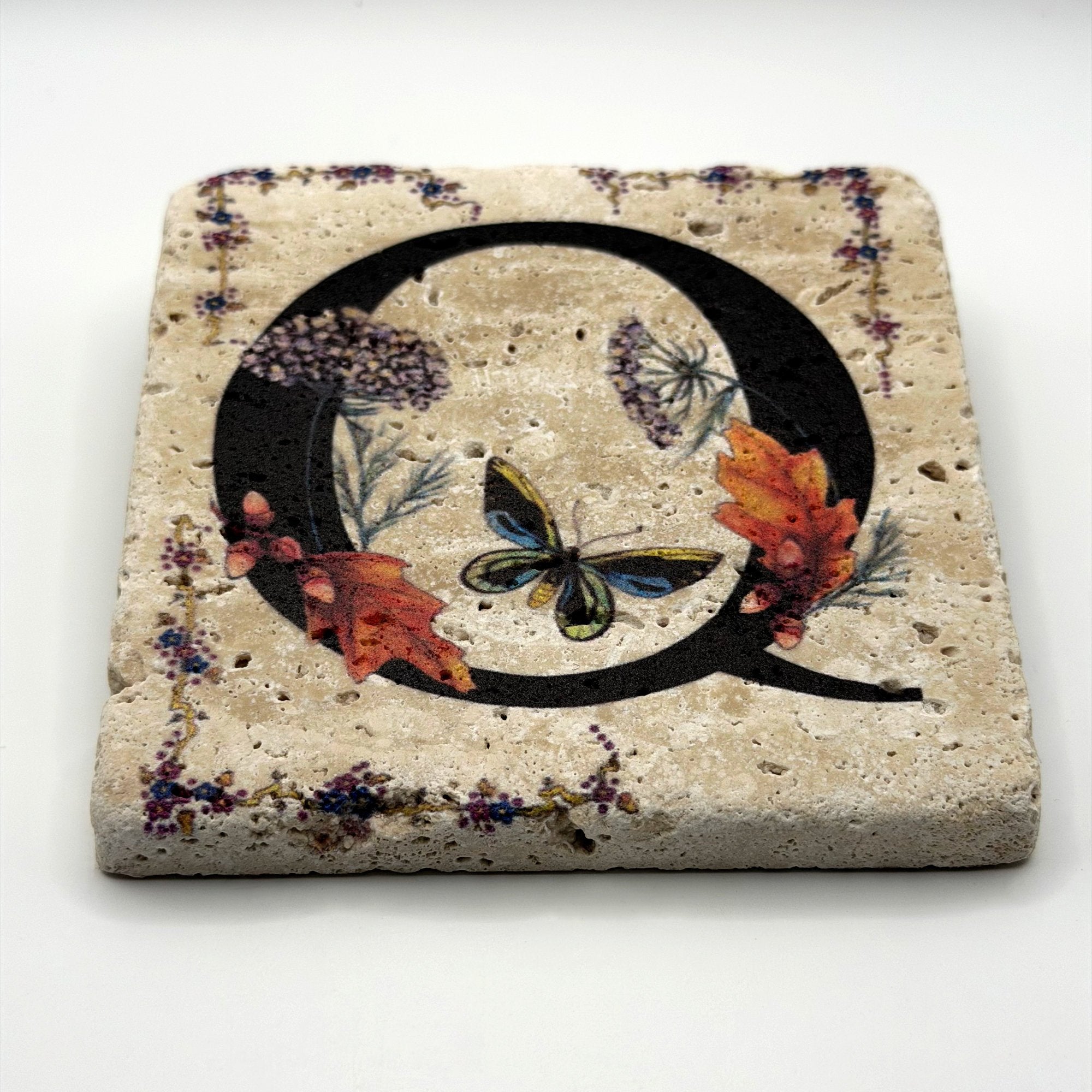 Alphabet letter Q design printed on a natural stone coaster