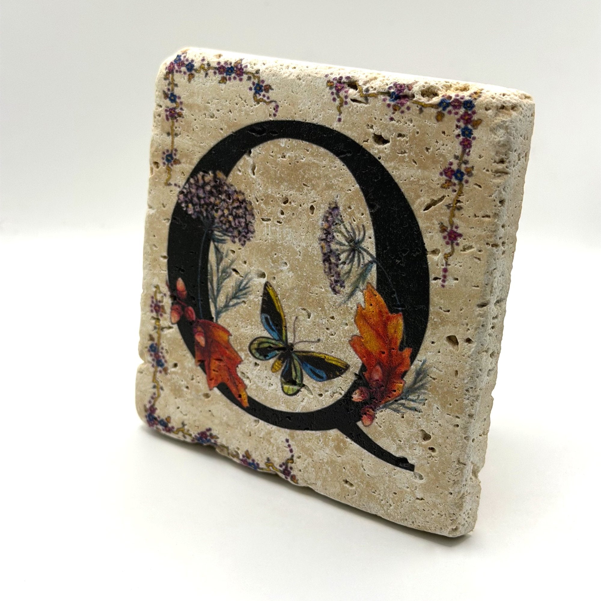 Alphabet letter Q design printed on a natural stone coaster