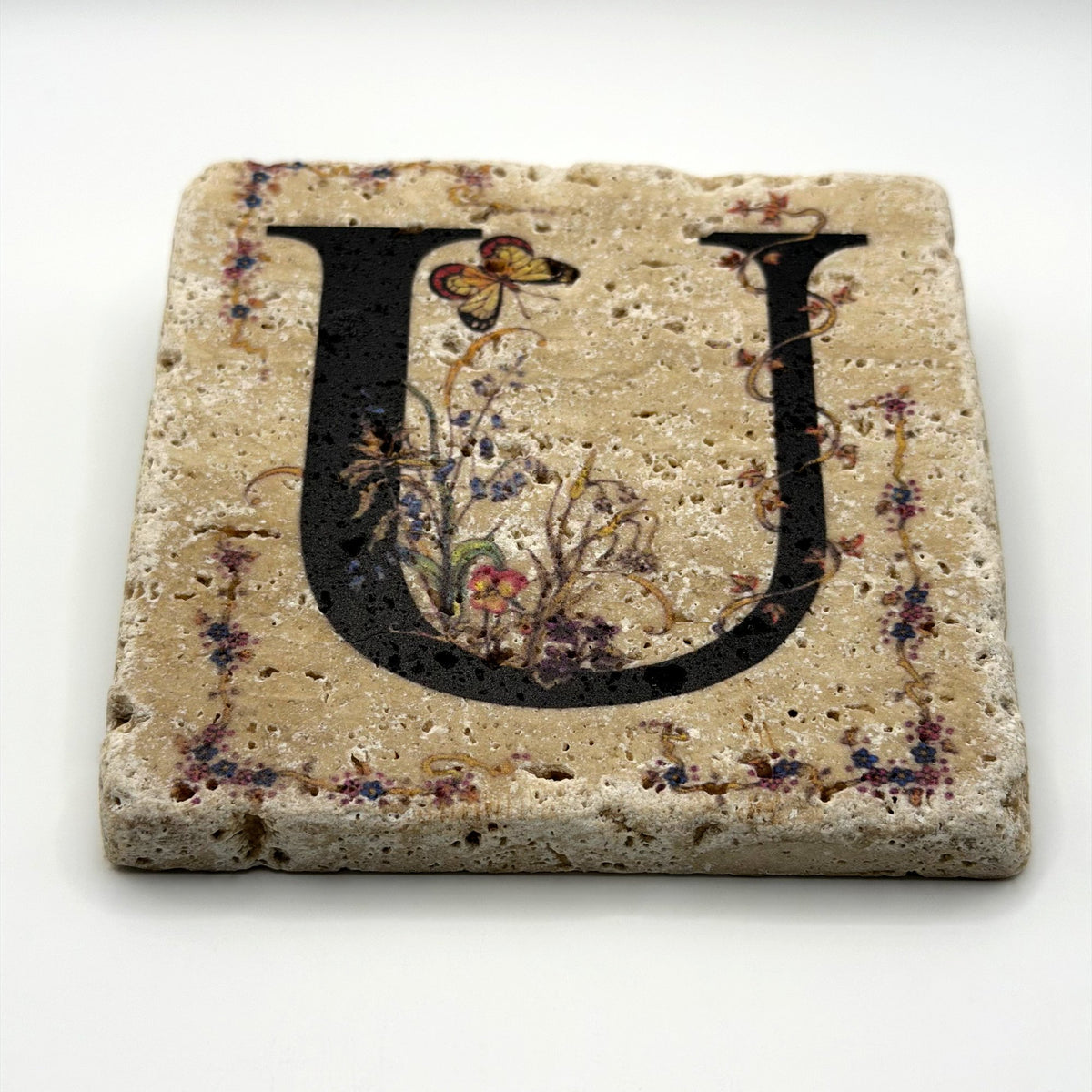 Alphabet letter U design printed on a natural stone coaster