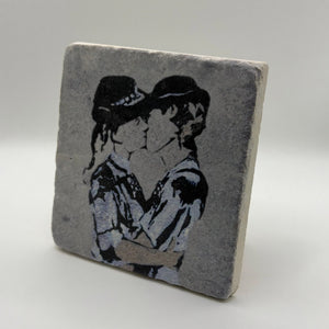 Banksy's 'Kissing Police Women' artwork printed on square natural travertine stone coaster