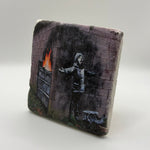 Banksy artwork featuring Santa Claus printed on square travertine stone coaster