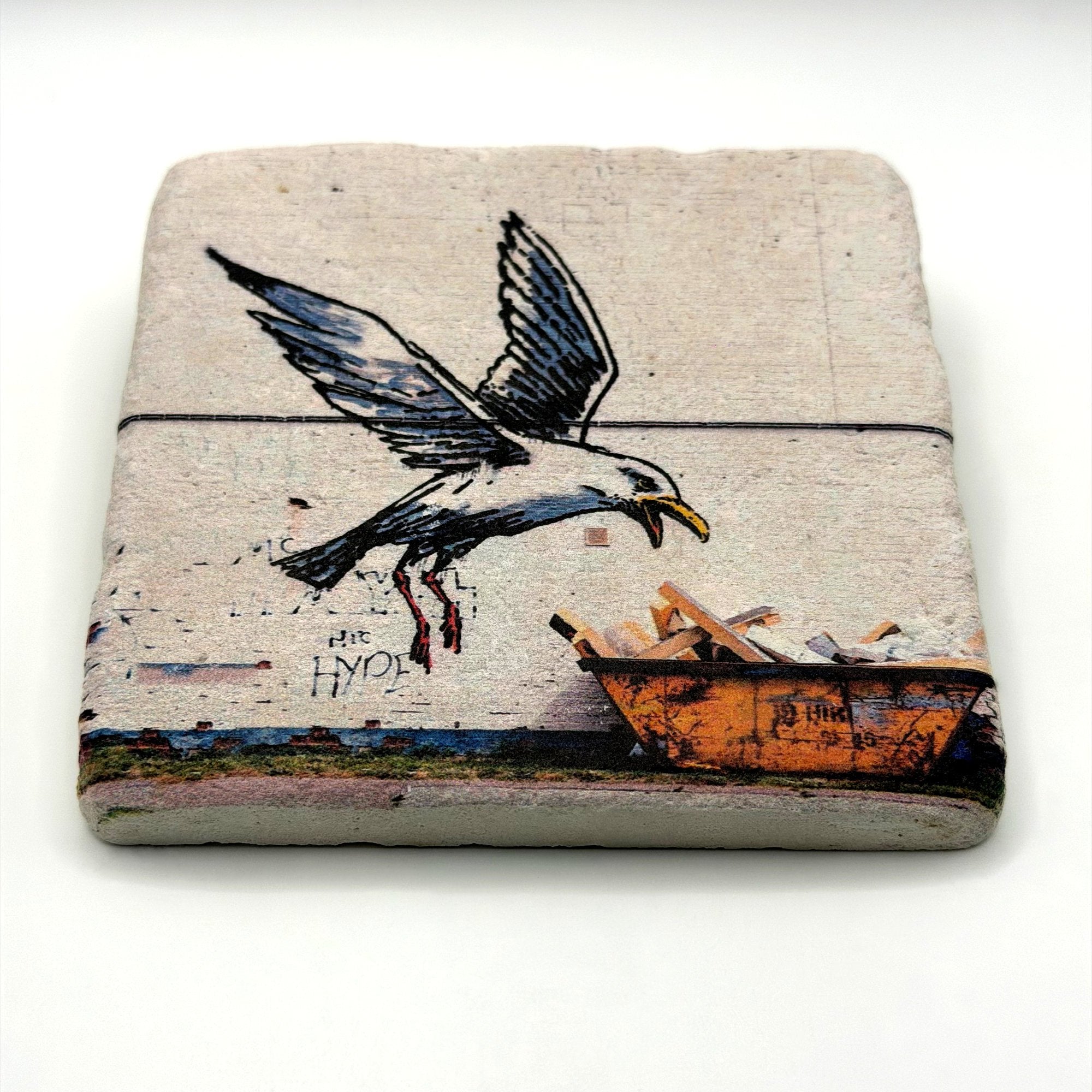 Banksy's Swooping Seagull artwork printed on square travertine stone coaster