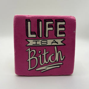 Sarcastic quote 'Life is a Bitch' printed on square travertine stone coaster