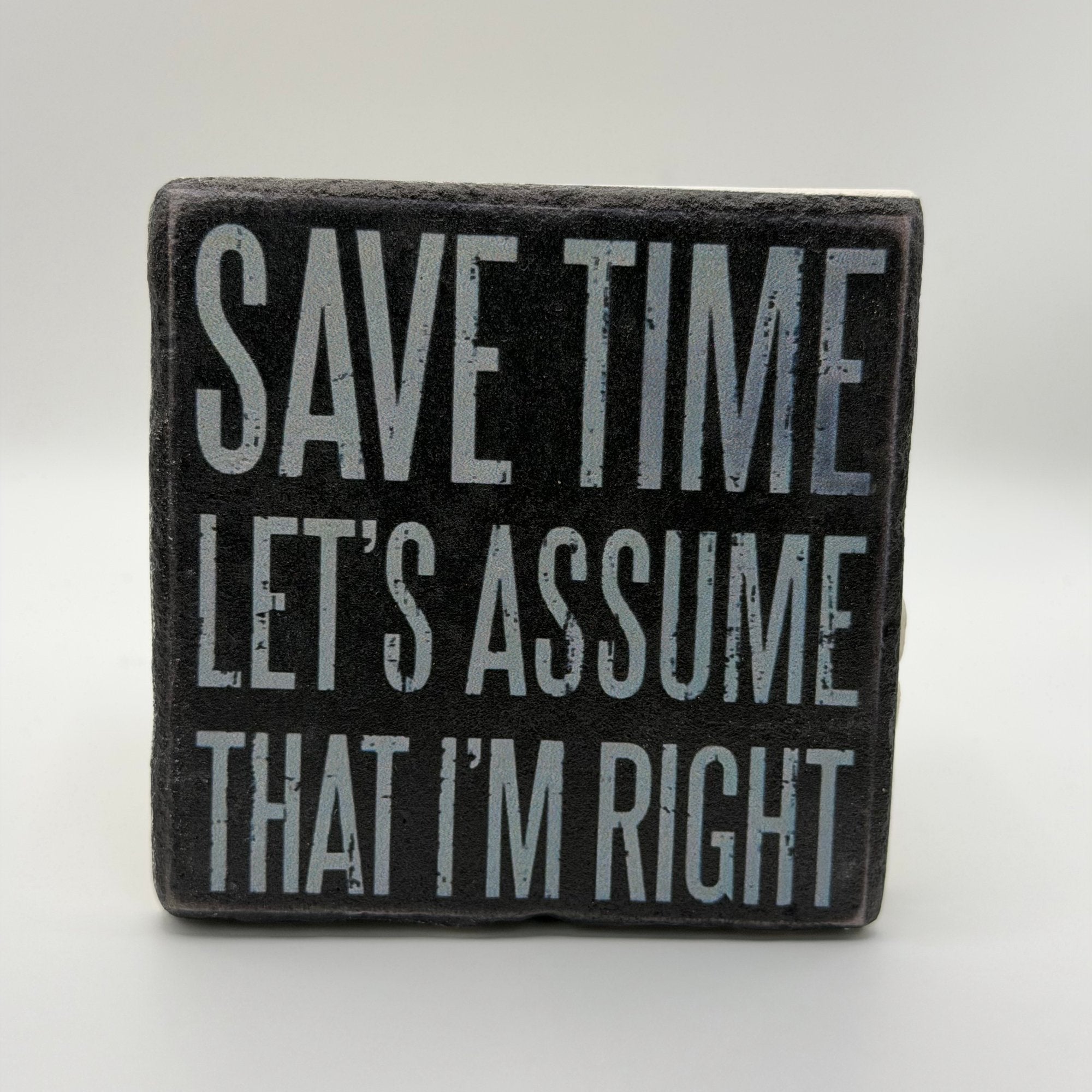 Funny quote about time assumptions printed on square travertine stone coaster