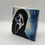 Skull artwork featuring a screaming face printed on square travertine stone coaster