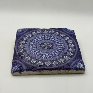Geometric patterns inspired by tribal cultures printed on square travertine stone coaster