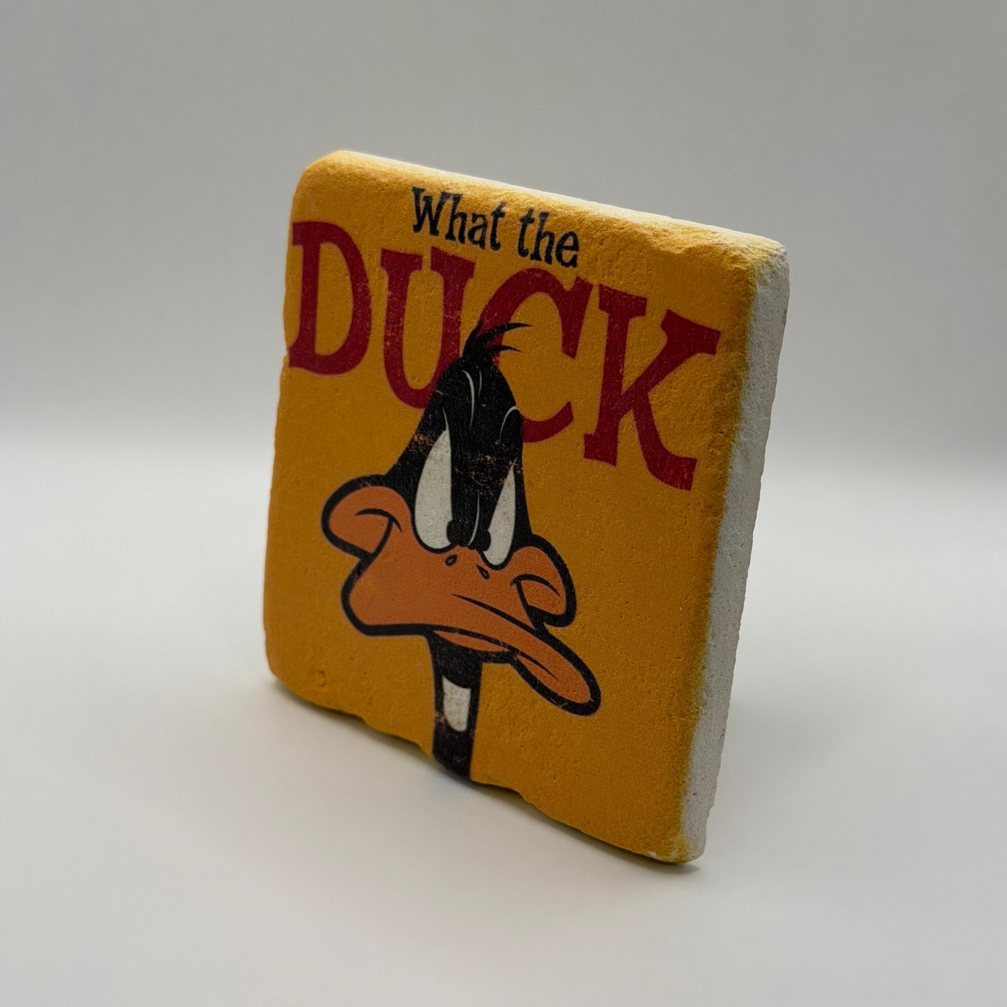 Comedic quote 'What The Duck' printed on square travertine stone coaster