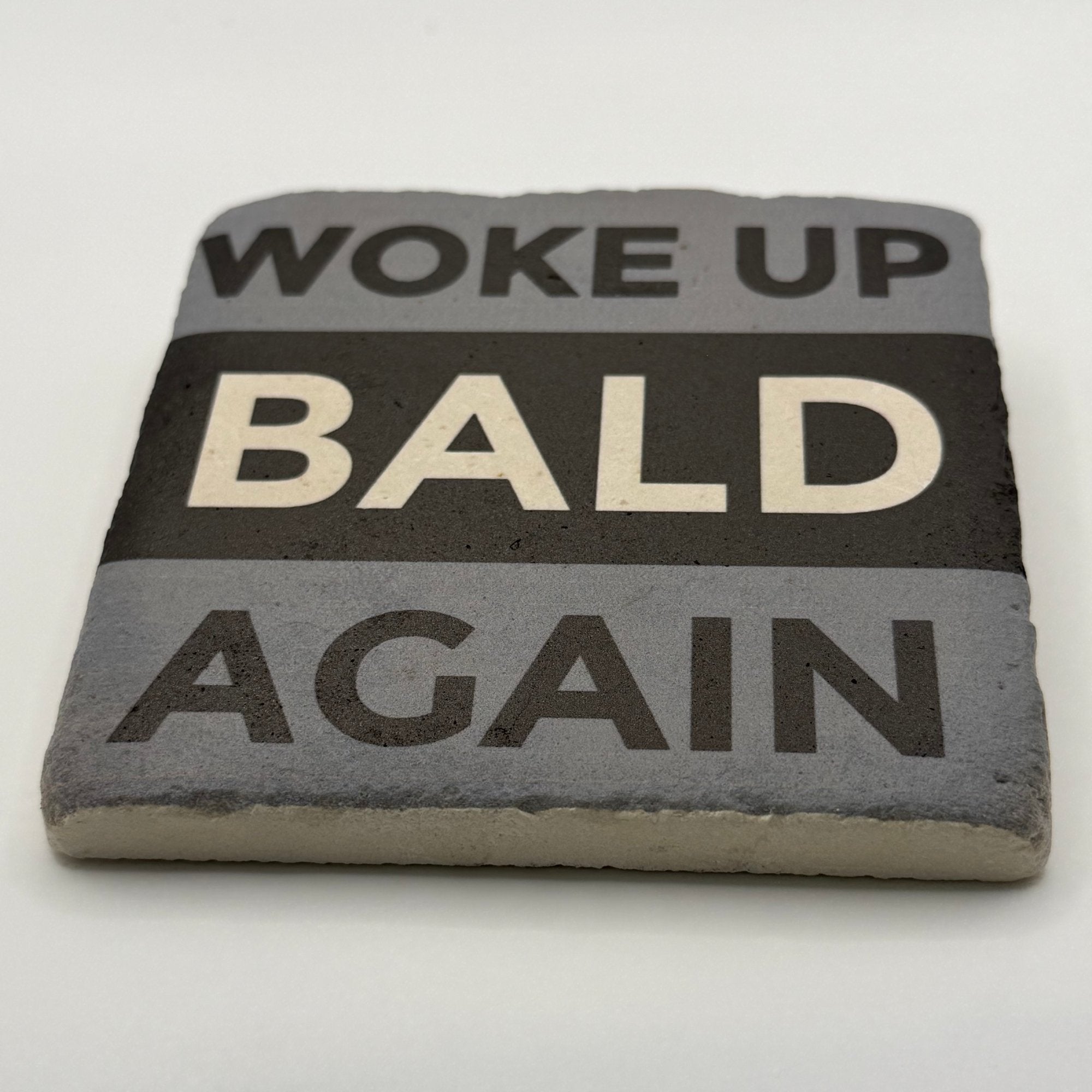 Woke Up Bald Again slogan printed on square travertine stone coaster