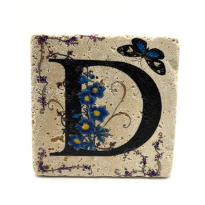 Alphabet letter D design printed on a natural stone coaster