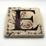 Alphabet letter E design printed on a natural stone coaster
