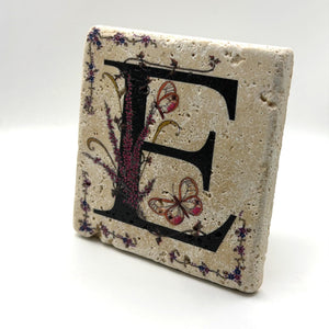 Alphabet letter E design printed on a natural stone coaster