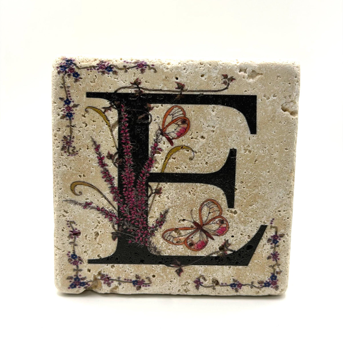 Alphabet letter E design printed on a natural stone coaster