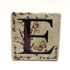 Alphabet letter E design printed on a natural stone coaster