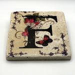 Alphabet letter F design printed on a natural stone coaster