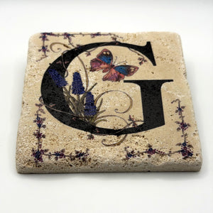 Alphabet letter G design printed on a natural stone coaster