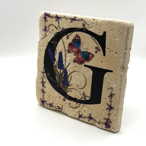 Alphabet letter G design printed on a natural stone coaster