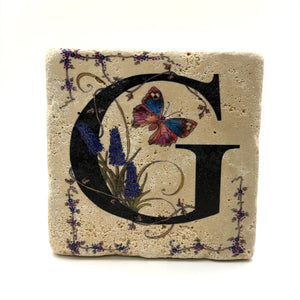 Alphabet letter G design printed on a natural stone coaster