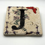 Alphabet letter J design printed on a natural stone coaster
