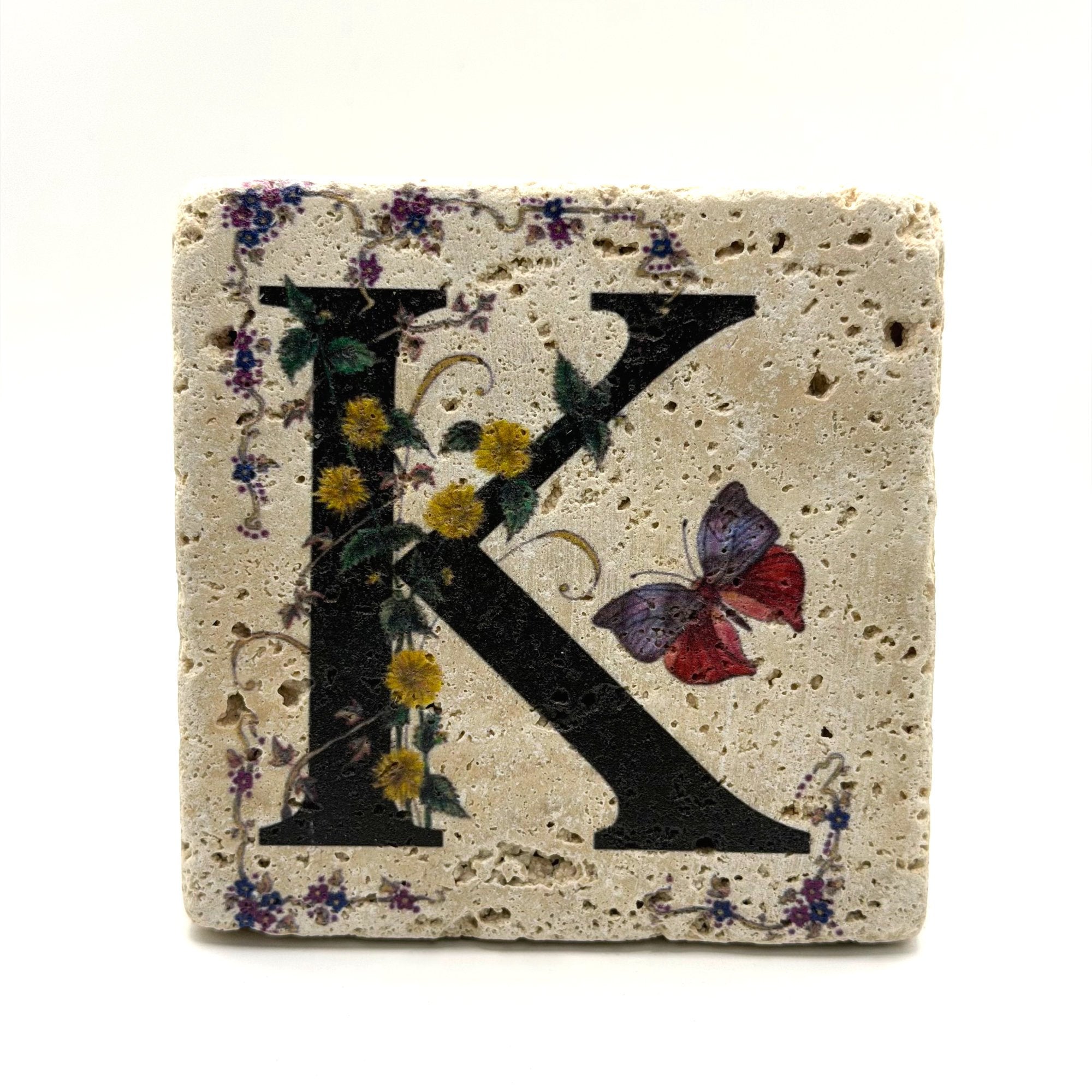 Alphabet letter K design printed on a natural stone coaster