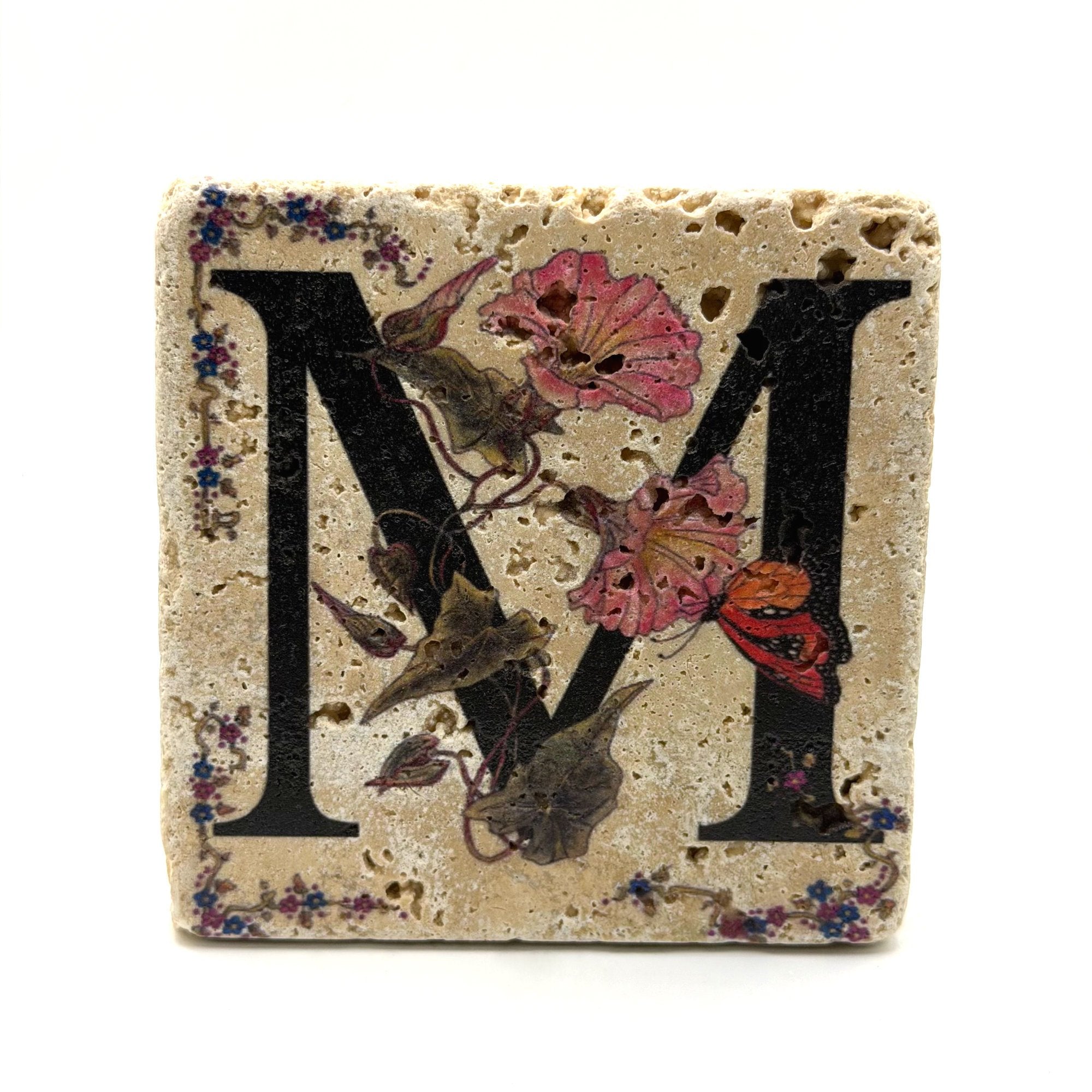 Alphabet letter M design printed on a natural stone coaster