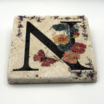 Alphabet letter N design printed on a natural stone coaster