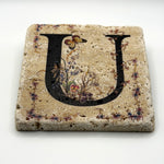 Alphabet letter U design printed on a natural stone coaster
