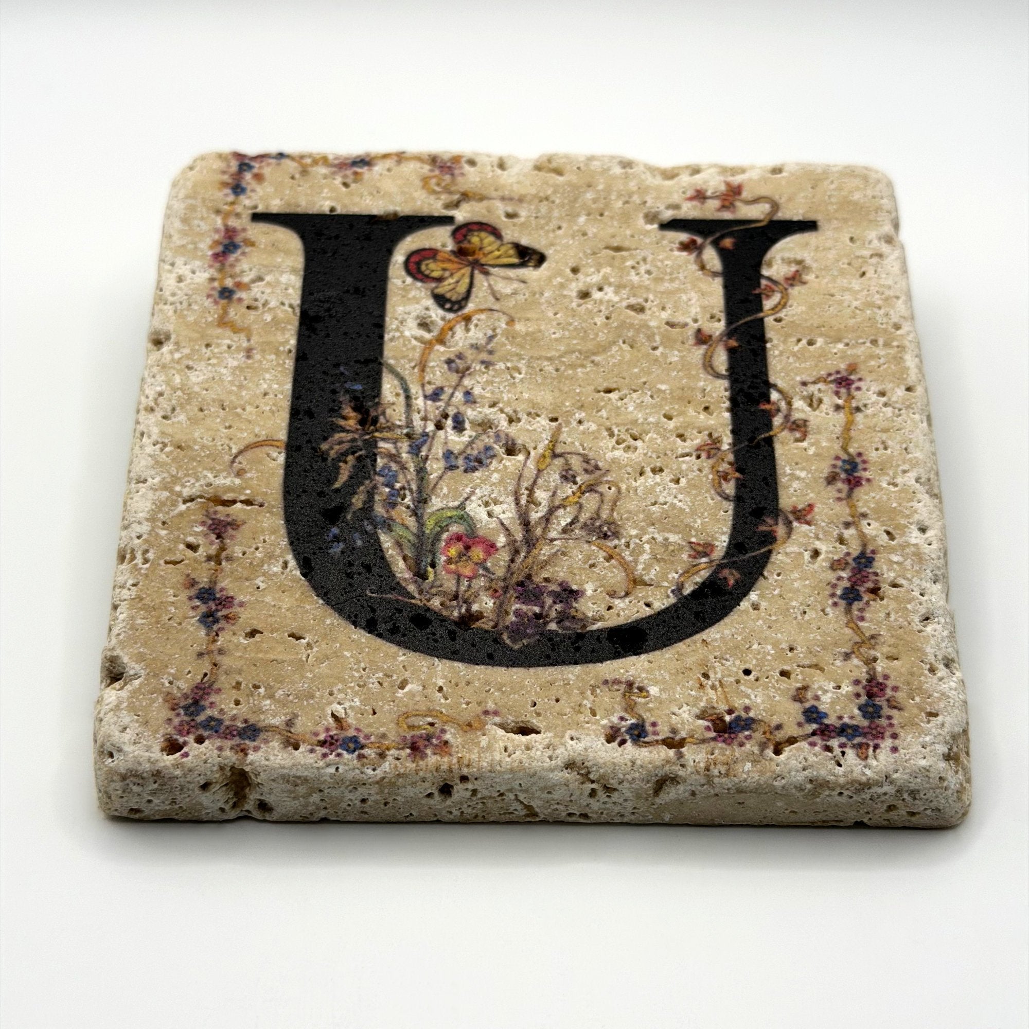 Alphabet letter U design printed on a natural stone coaster