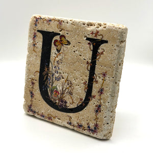 Alphabet letter U design printed on a natural stone coaster