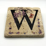 Alphabet letter W design printed on a natural stone coaster