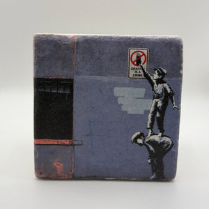 Banksy's 'Graffiti Is A Crime' artwork printed on square travertine stone coaster