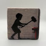Banksy's Hammer Boy artwork printed on square travertine stone coaster