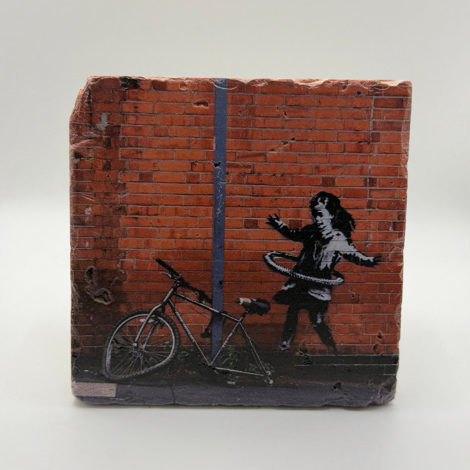 Banksy's Hula Hoop Girl artwork printed on square travertine stone coaster