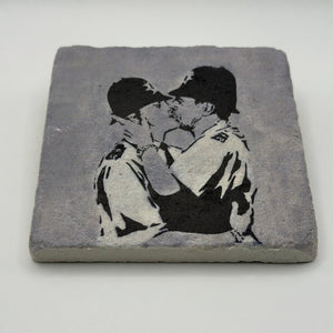 Banksy artwork featuring kissing coppers printed on square travertine stone coaster