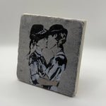 Banksy's 'Kissing Police Women' artwork printed on square natural travertine stone coaster