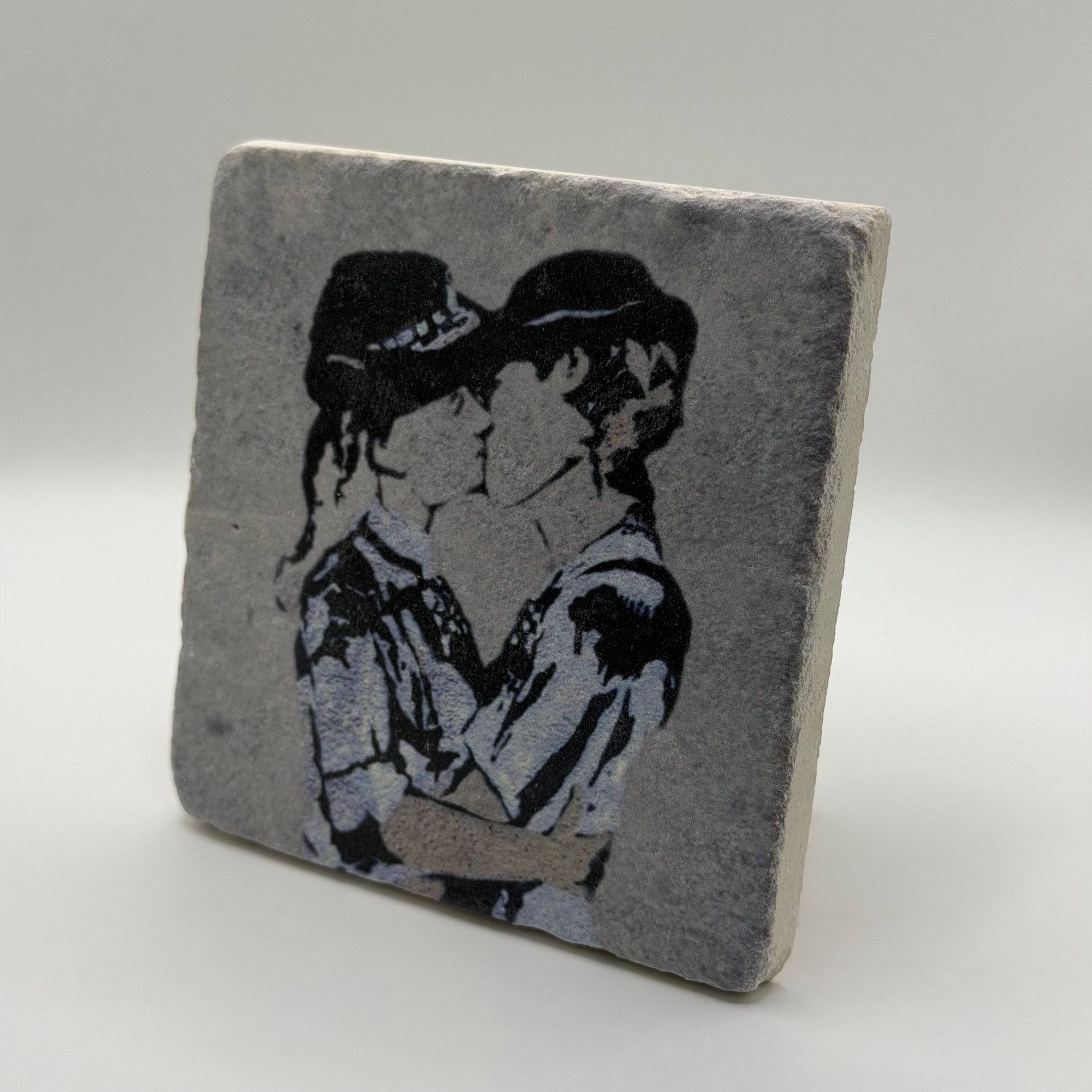 Banksy's 'Kissing Police Women' artwork printed on square natural travertine stone coaster