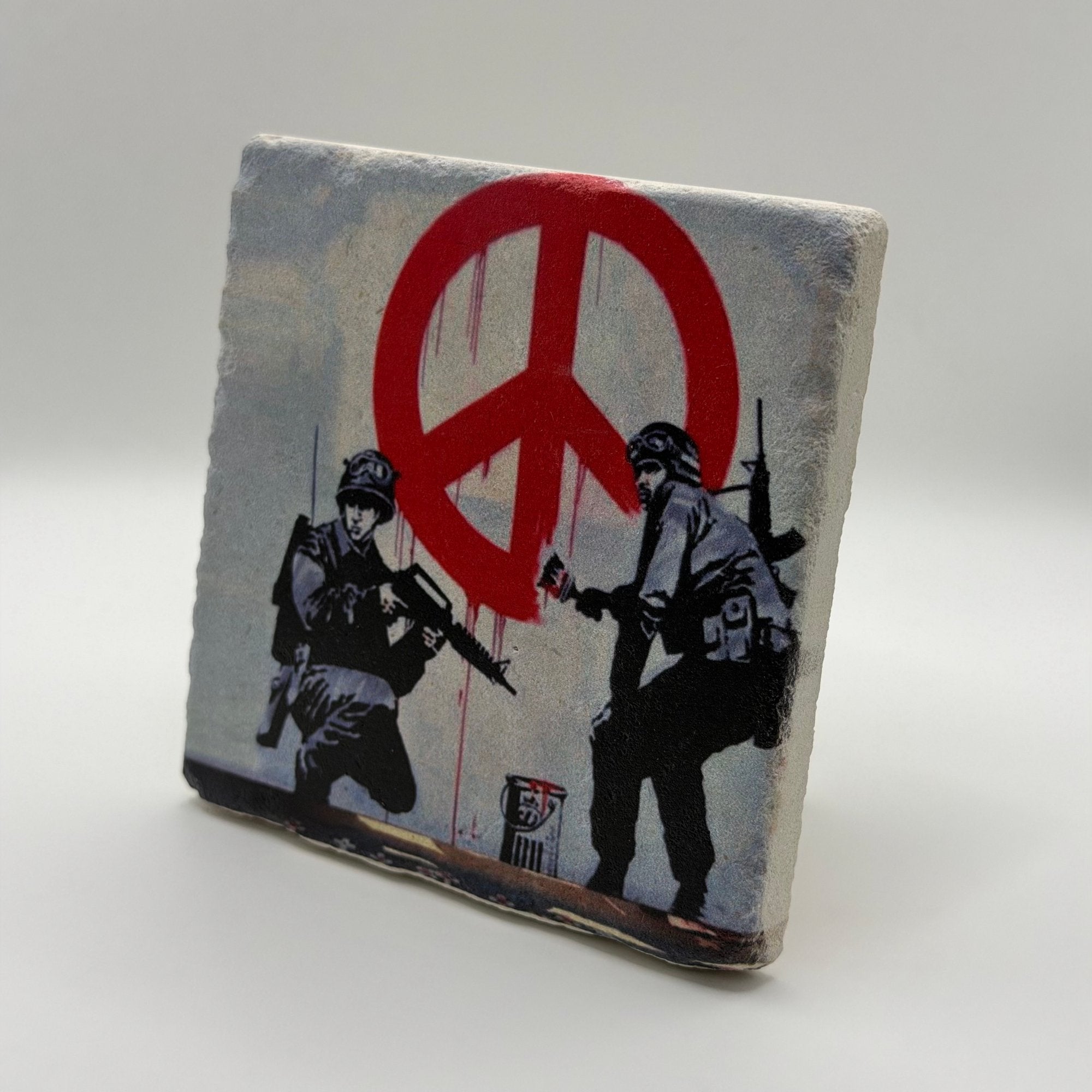Banksy artwork featuring peace soldiers printed on square travertine stone coaster