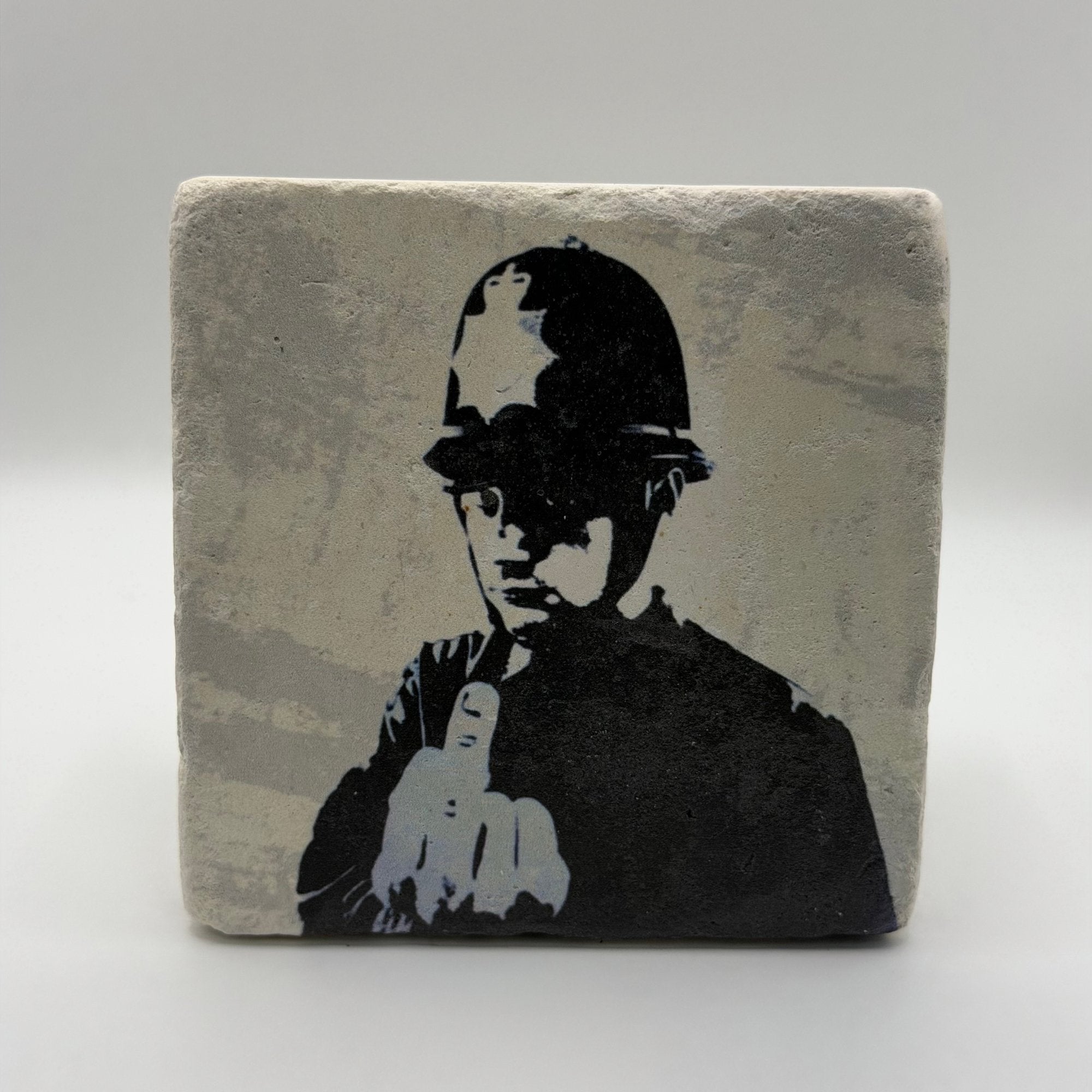 Banksy artwork featuring 'Rude Copper' design printed on square travertine stone coaster