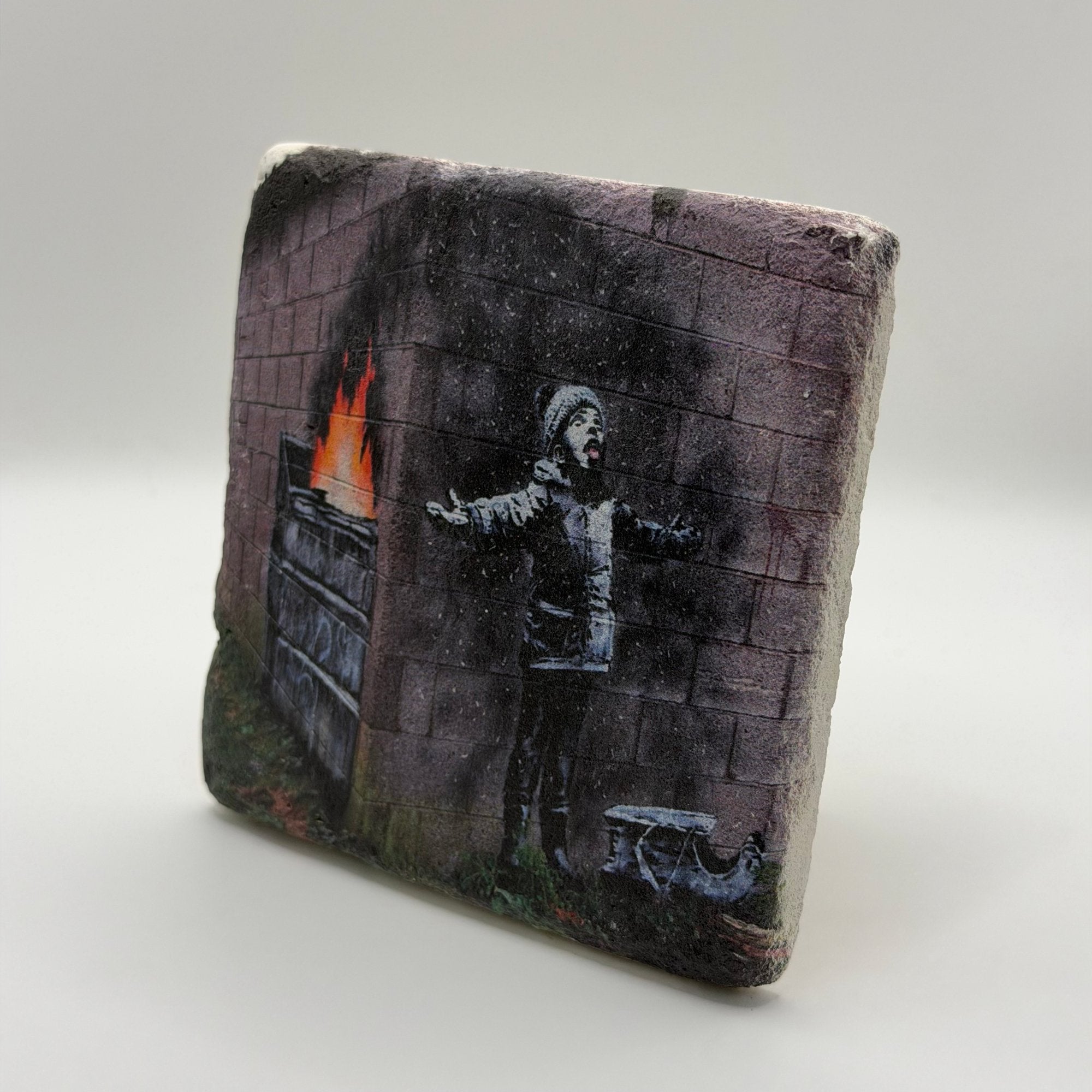 Banksy artwork featuring Santa Claus printed on square travertine stone coaster