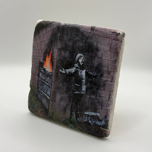 Banksy artwork featuring Santa Claus printed on square travertine stone coaster