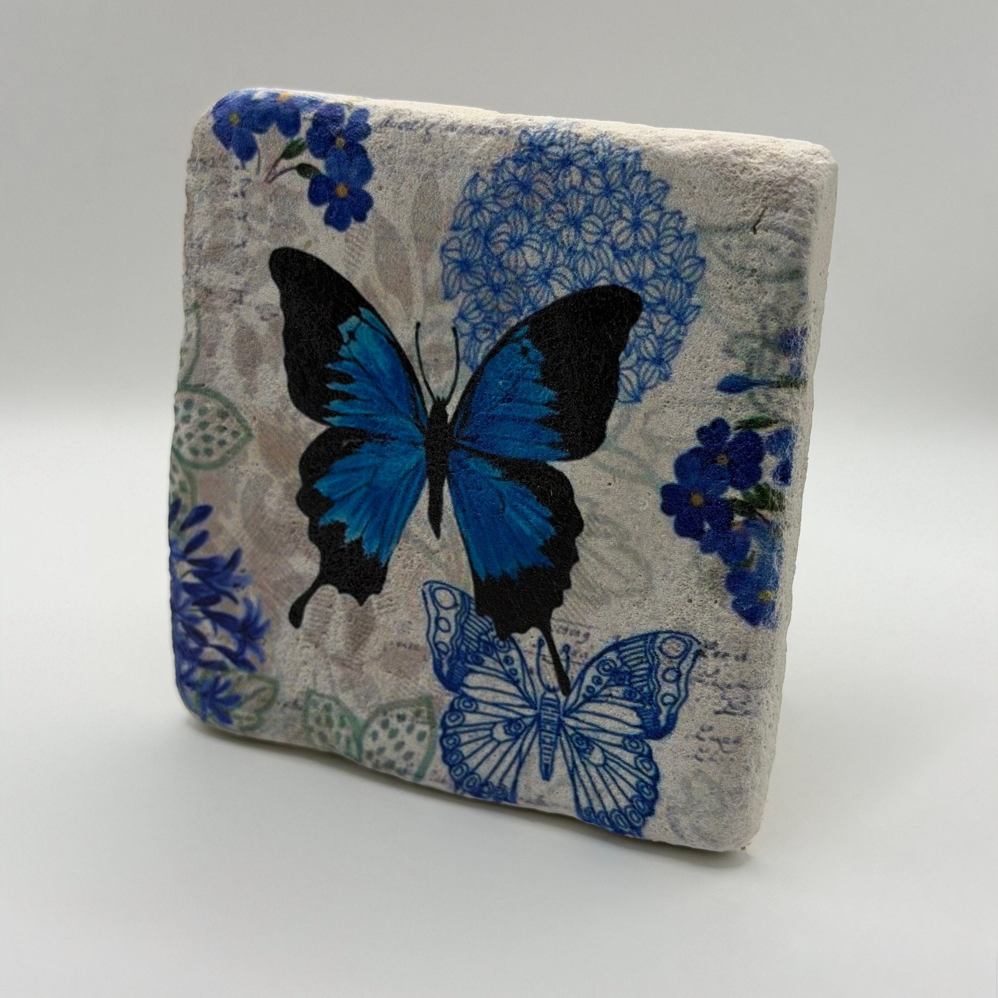 Delicate blue butterfly artwork printed on square travertine stone coaster